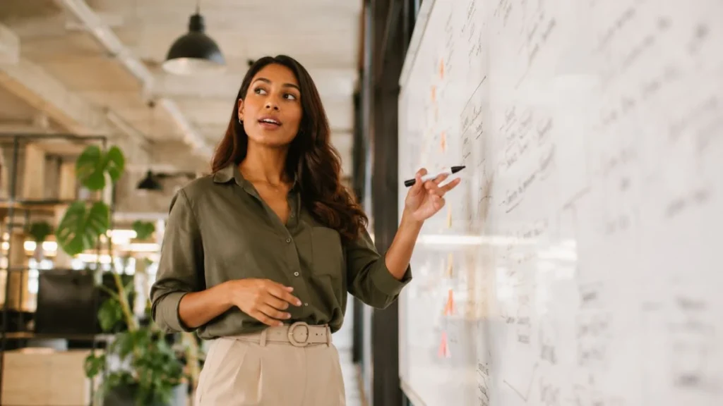 Marketing manager at a campaign planning whiteboard — AI tools for marketing managers in a modern creative office.