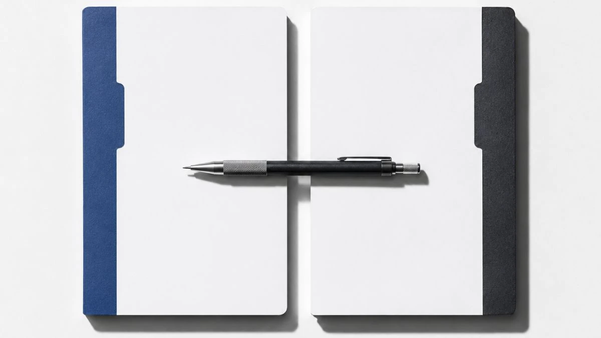 Two parallel notebooks on a white desk representing a make vs zapier platform comparison for workflow automation.