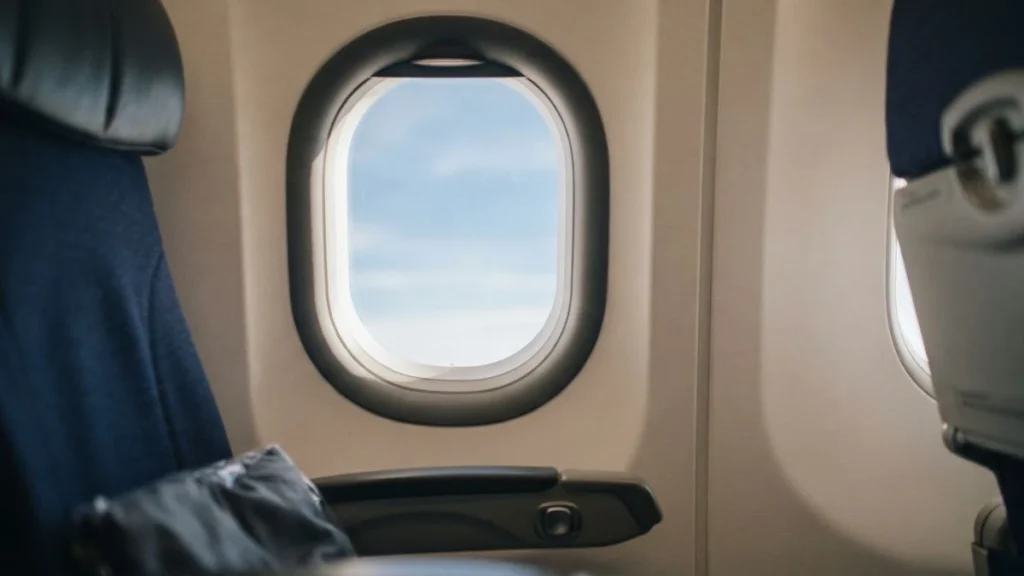 Close-up of a rounded airplane cabin window showing its oval shape