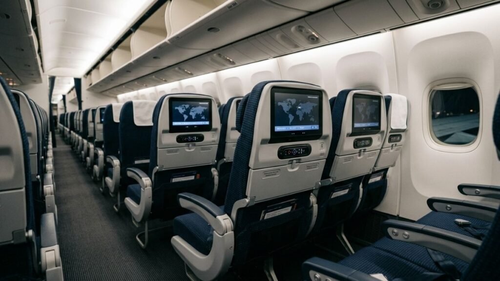 Economy class cabin interior with personal entertainment screens